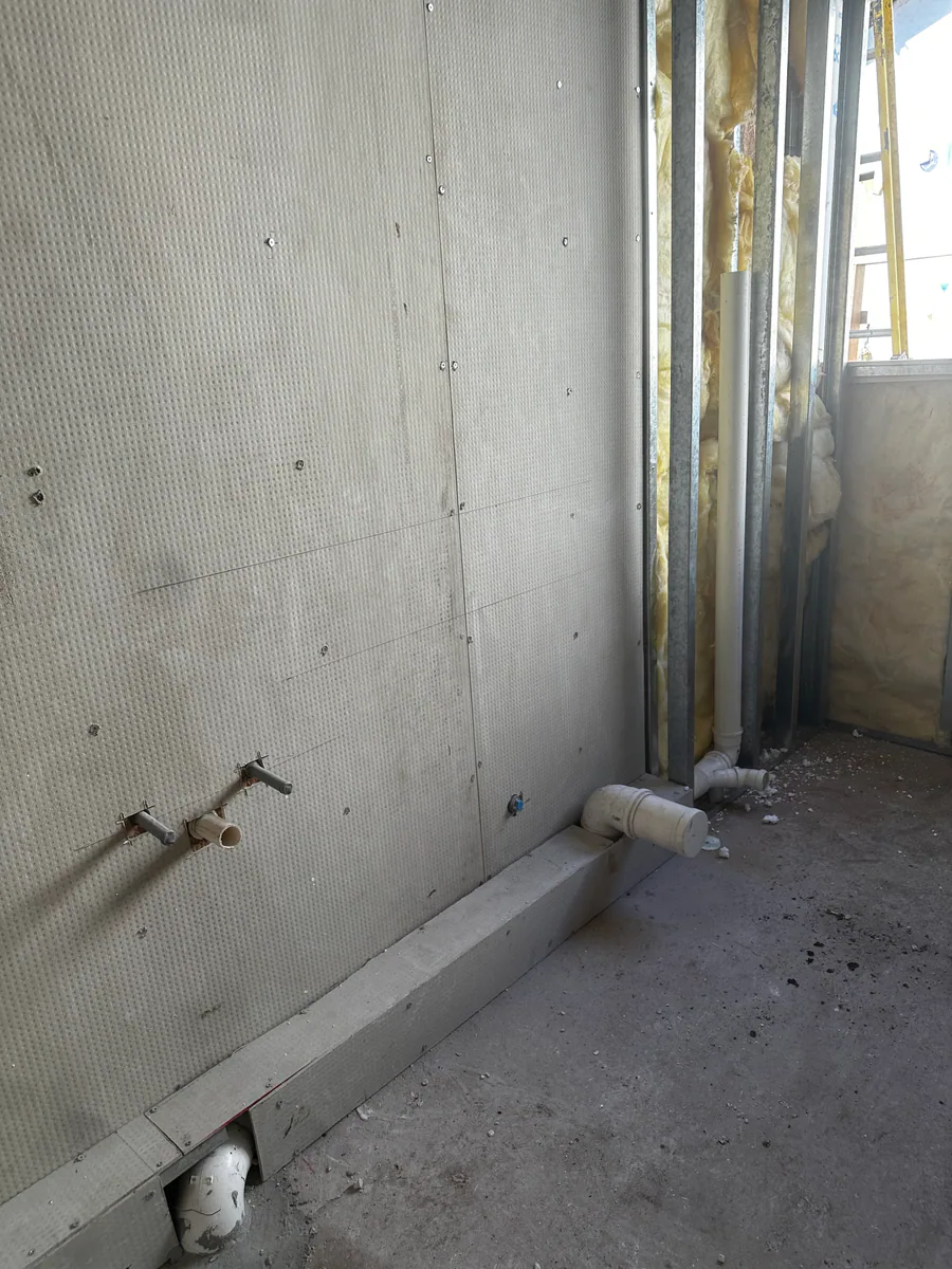 Tuberías verticales instaladas junto al tabique en construcción